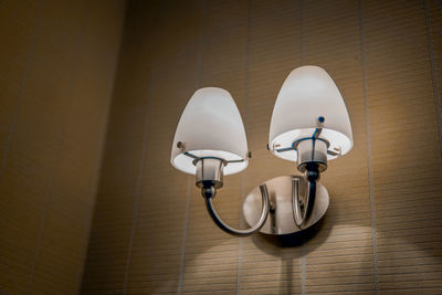 Low angle view of electric lamp mounted on wall