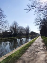 View of footpath by canal against sky