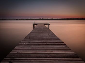 Pier on sea at sunset