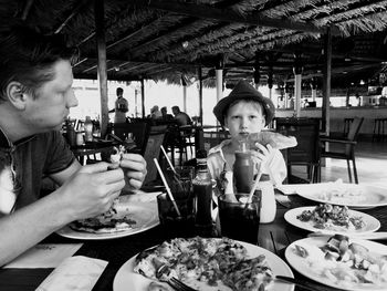 High angle view of boy sitting on table at restaurant