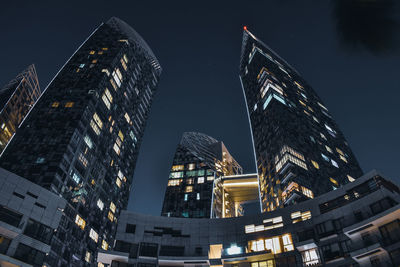 Low angle view of illuminated buildings against sky at night