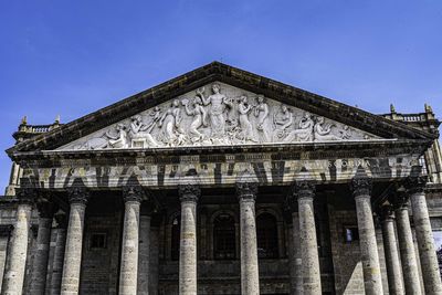 Low angle view of historical building against blue sky