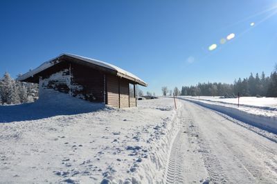 Snow covered landscape against clear blue sky