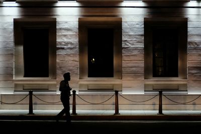 Silhouette woman standing in illuminated building