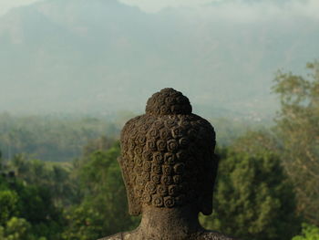 Close-up of buddha statue against plants