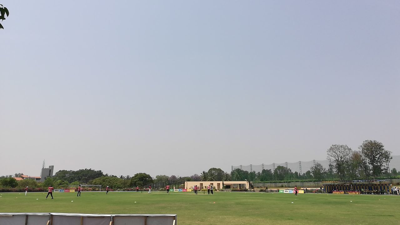 PEOPLE PLAYING SOCCER FIELD AGAINST SKY