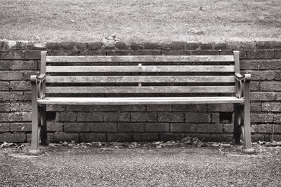 Empty bench on field in park
