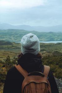 Rear view of girl looking at mountains against sky