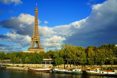 Boats in city against cloudy sky