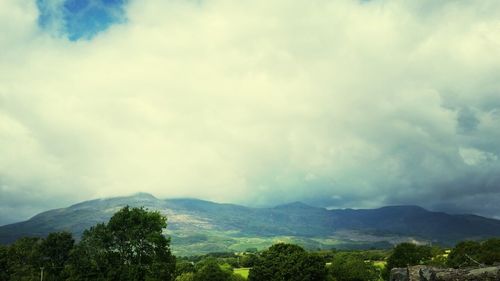 Scenic view of mountains against cloudy sky