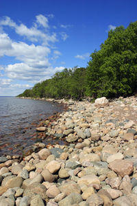 Stone wall by sea against sky