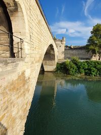 Arch bridge over river against sky