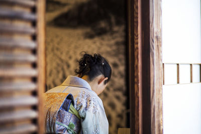 Rear view of woman on window