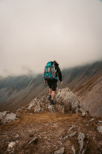 Rear view of man on mountain against sky