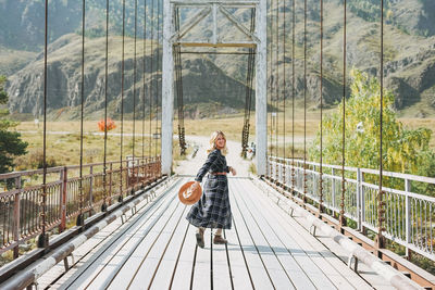 Woman walking on footbridge