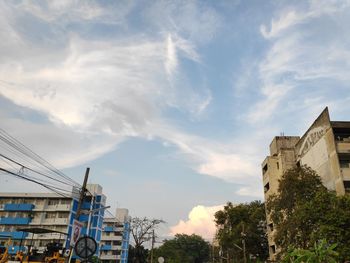 Low angle view of buildings against cloudy sky