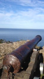 Rusty metal by sea against sky