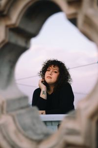 Portrait of young woman looking to the camera at sunset