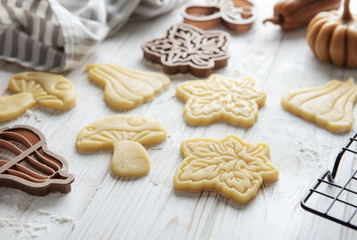 Baking cookies in the form of pumpkin and leaves. cozy autumn pastry. dough with cookie cutters.