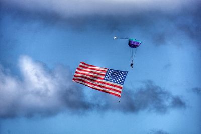 Person paragliding with american flag in sky