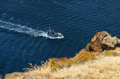 High angle view of man in boat at blue sea