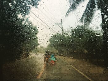 Raindrops on road seen through wet window
