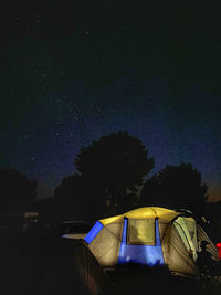 Low angle view of illuminated tent against sky at night