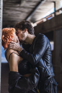 Young couple kissing in underpass