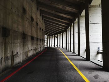 Empty road by architectural columns