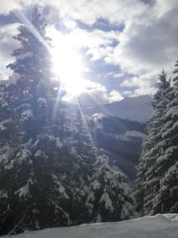 Low angle view of snow covered mountains against sky