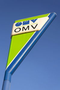 Low angle view of information sign against clear blue sky