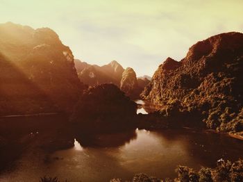 Scenic view of river and mountains against sky