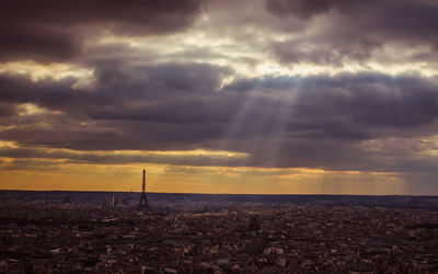 Scenic view of dramatic sky over city during sunset