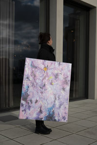 Low section of woman standing against wall