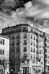 Low angle view of buildings against cloudy sky