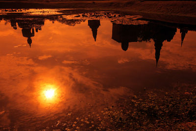 High angle view of silhouette buddha statue at wat muang reflection in puddle