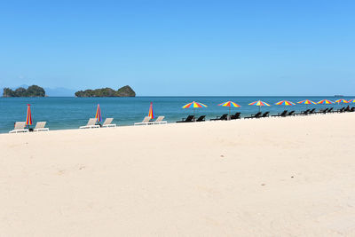 Scenic view of beach against clear blue sky