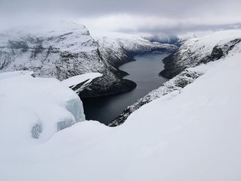 Frozen lake against snowcapped mountains