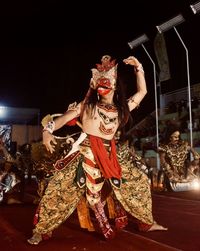 Female sculpture in traditional clothing at night