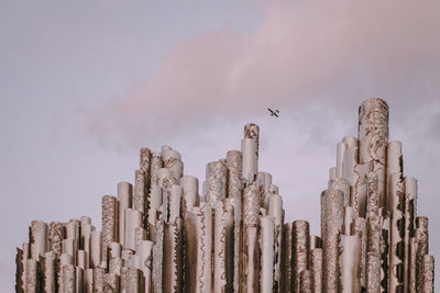 Low angle view of wooden posts against sky