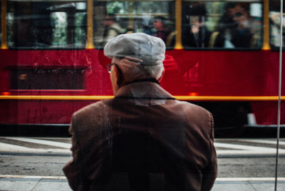 Rear view of man standing at railroad station