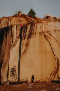 People on rock formations against sky