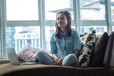 Young woman using mobile phone at home