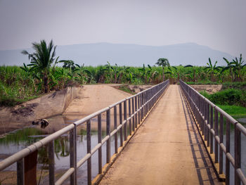 Road leading towards gazebo against sky