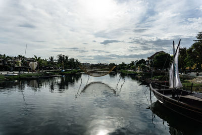 Boats moored in water against sky