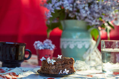 Aesthetic homemade chocolate cake. dessert and cup of coffee among flowers. atmospheric breakfast