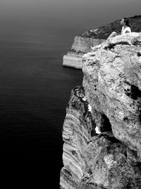 Rock formation on sea shore against sky