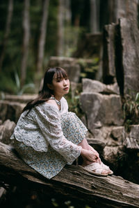 Portrait of young woman sitting on rock