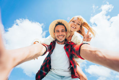 Portrait of happy friends against sky