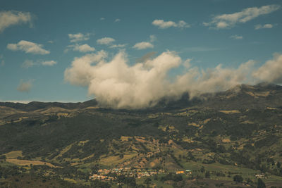 Smoke emitting from volcanic landscape against sky